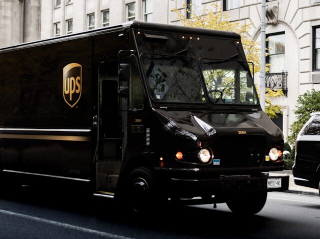 a ups truck driving down a city street